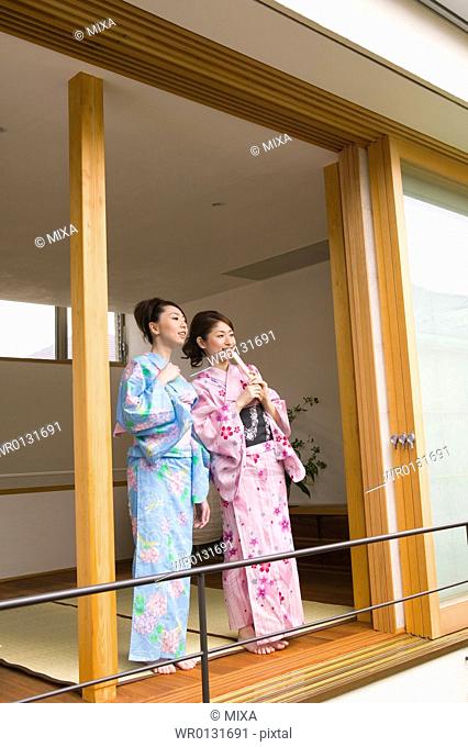 Two young women wearing yukata standing