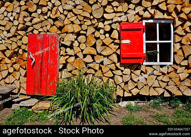 Fenster als Dekoration in einem Brennholzstapel, Window as decoration in a firewood pile