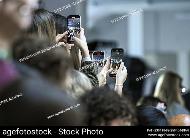 17 January 2023, Berlin: Young women and men hold their smartphones and film a fashion show at Berlin Fashion Week. Berlin Fashion Week takes place from January...