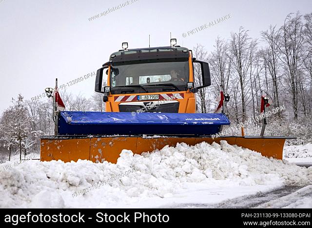 30 November 2023, North Rhine-Westphalia, Lüdenscheid: A clearing vehicle from Autobahn GmbH clears snow from the parking spaces and roadways in a parking lot...