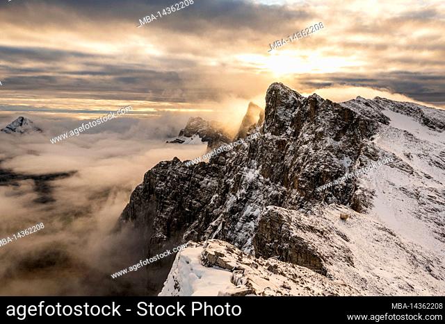The small silver Karl-Schuster bivouac below the Dreizinkenspitze on the Lalidererwand in late autumn during sunrise with snow and clouds