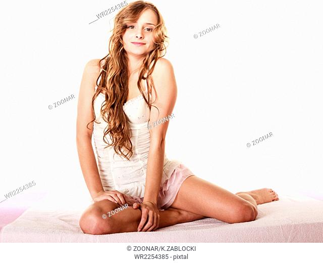 woman long curly hair relaxing on her bed at morning