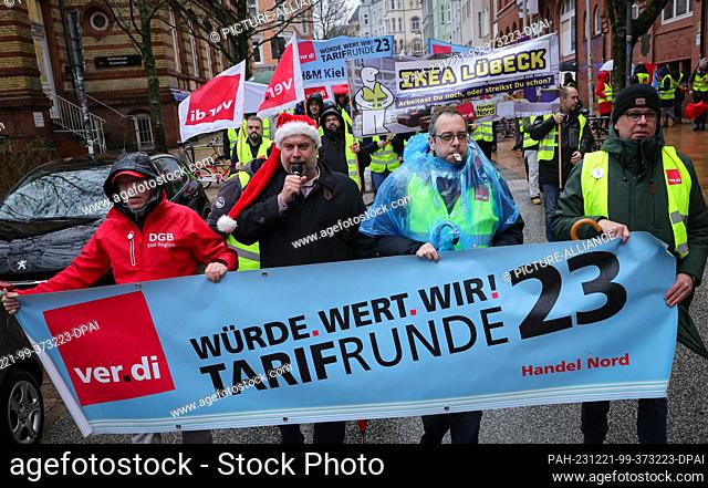 21 December 2023, Schleswig-Holstein, Kiel: Participants in a warning strike march with Verdi union flags and a banner reading ""Dignity. Values