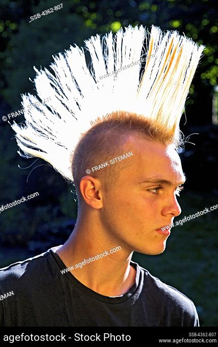 A 14-year-old teenage boy with bleached hair and a spiked mohawk haircut