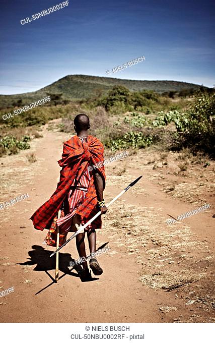 Maasai man walking on dirt road