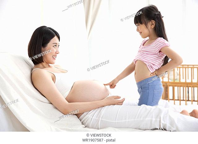 The little girl pointed to the mother's belly