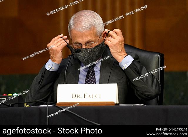 Dr. Anthony Fauci, director of the National Institute of Allergy and Infectious Diseases, puts his mask back on during a Senate Health, Education