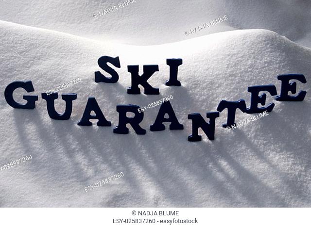 Blue Letters Building English Text Ski Guarantee On White Snow. Snowy Landscape Or Scenery. Christmas Card For Seasons Greetings Or Usable As Background