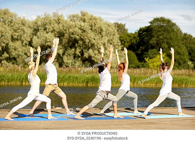 group of people making yoga exercises outdoors
