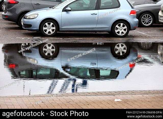 14 December 2023, Mecklenburg-Western Pomerania, Rostock: Cars are reflected in a large puddle in the city harbor. The thawing and rainy weather of the past few...