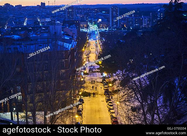 View of Atenas park and Ronda de Segovia street from the heights with people taking pictures and enjoying the snowy landscape on January 11, 2021 in Madrid