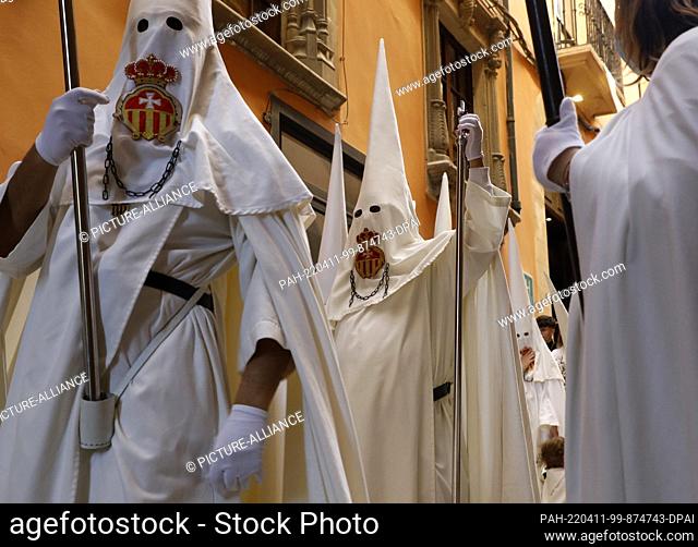 10 April 2022, Spain, Palma: Penitents wear pointed hoods and participate in the Palm Sunday procession. The procession had been canceled since 2019 because of...