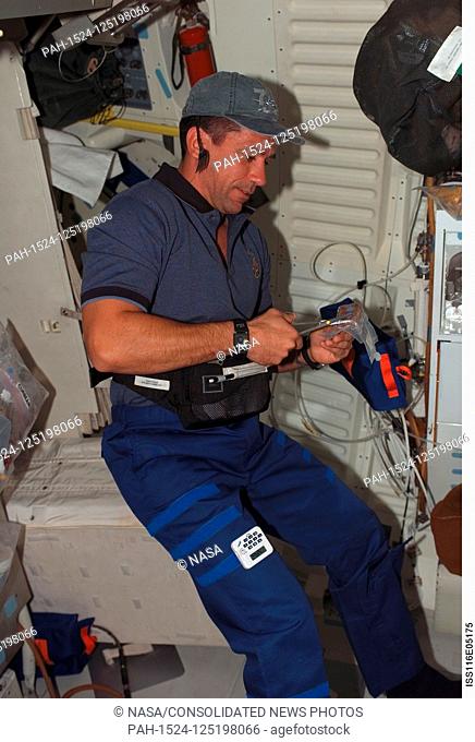 FILE: In this photo released by NASA, Astronaut William A. (Bill) Oefelein, STS-116 pilot, opens a package of food on the middeck of Space Shuttle Discovery in...