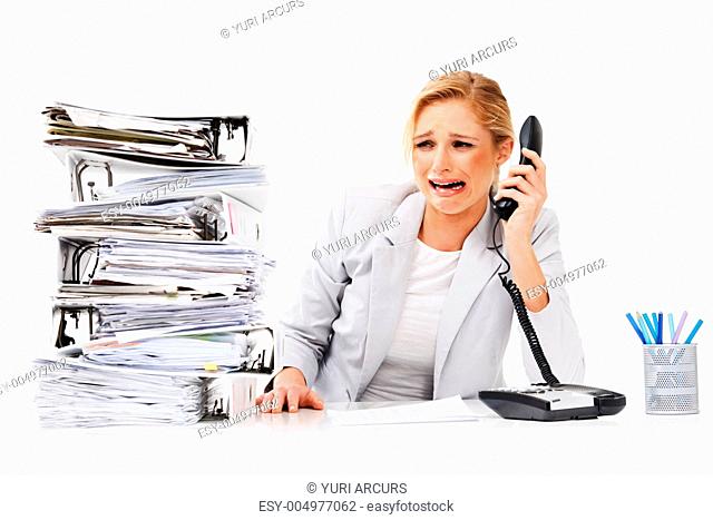 An absolutely distraught executive crying into a phone receiver next to a tall pile of files