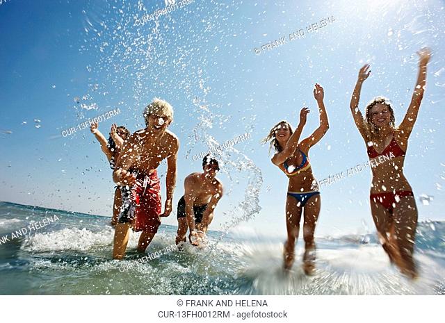 Group of people splashing in the sea