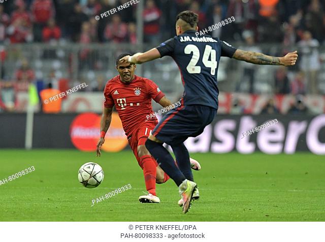 Munich's Douglas Costa (L) fights for the ball with Madrid's Jose Maria Gimenez during the Champions League semi-final second leg soccer match between Bayern...