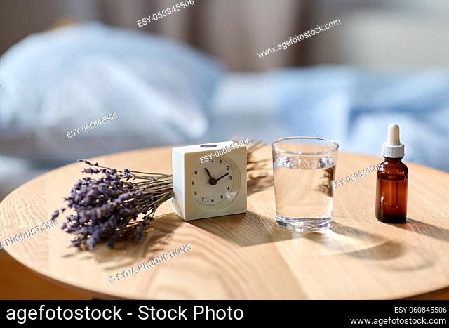 alarm clock, lavender oil and glass of water