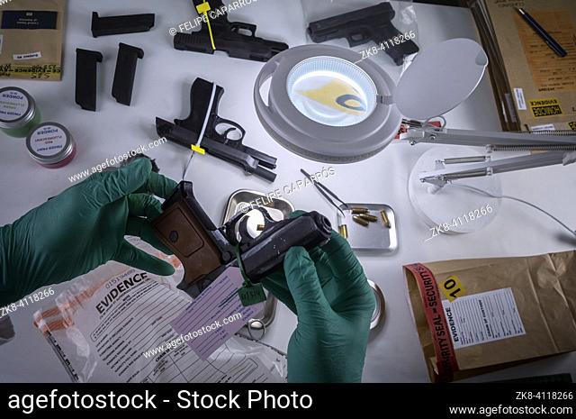 Scientific police officer examining traces of a gun in ballistic laboratory