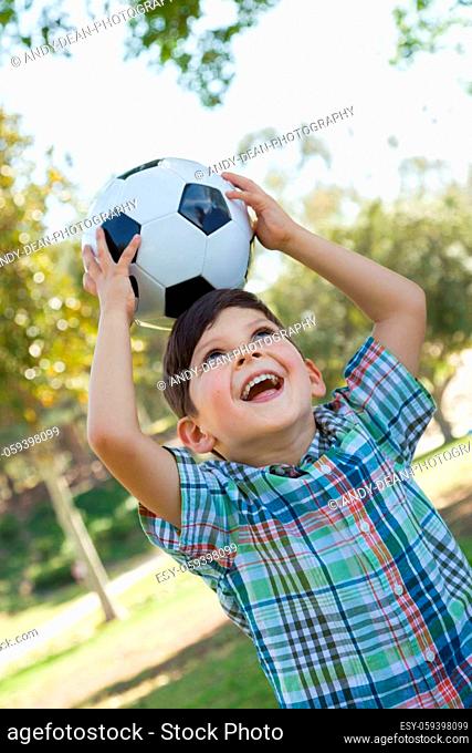 Cute Young Boy Playing with Soccer Ball Outdoors in the Park