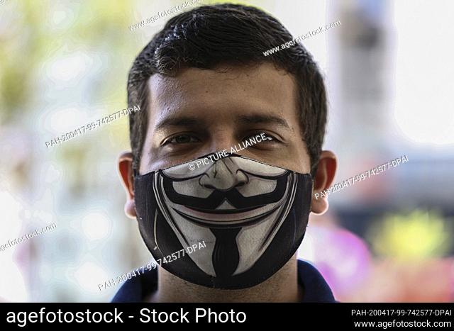 15 April 2020, Venezuela, Caracas: In the middle of the Corona pandemic, a man and woman are wearing a face mask with the image of the Anonymous mask on it