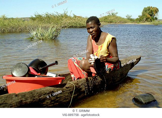 NAMIBIA, Living at Chobe river, the border river to Botswana in the Namibian Caprivi. Our picture shows a woman sitting in a dugout canoe washing dishes in the...
