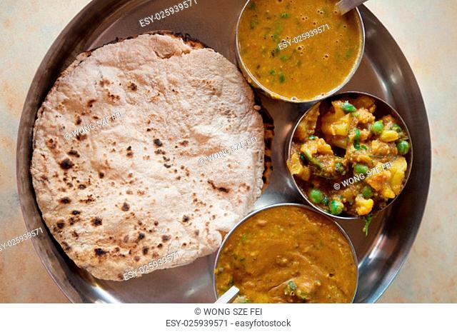 Traditional Indian food vegetarian roti served in small bowls on a round tray