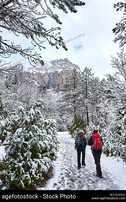Pyrenees: Two women hiking along snowy path in the National park of Ordesa and Monte Perdido (Huesca province, Aragon region, Spain)