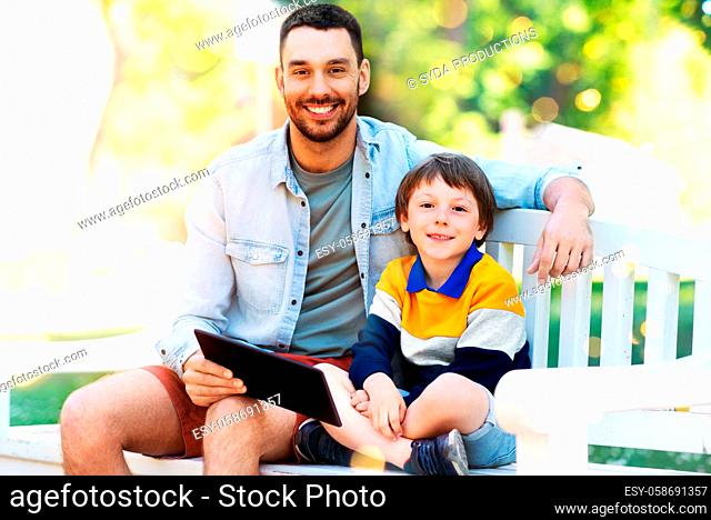 father and son with tablet pc computer at park