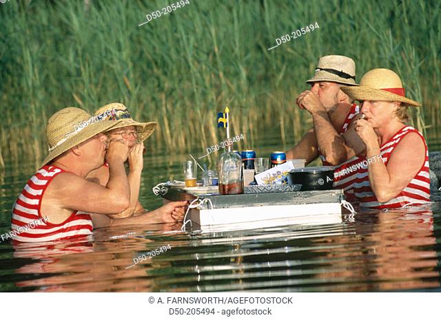 Two couples dine in water. Lake Vattern. Sweden