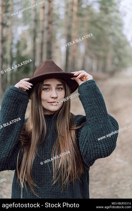 Young woman with long hair wearing hat on field