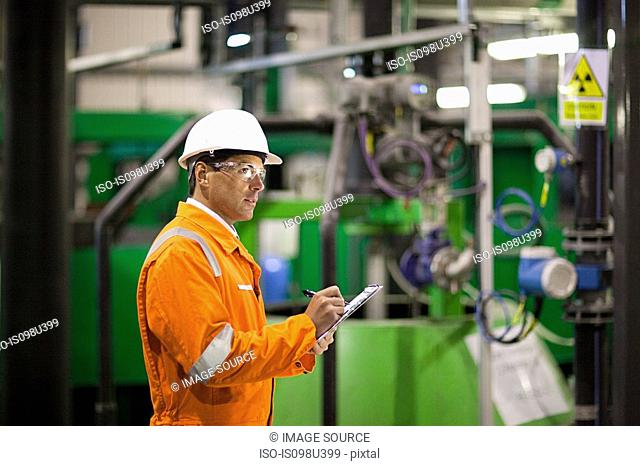 Engineer inspecting machinery in factory