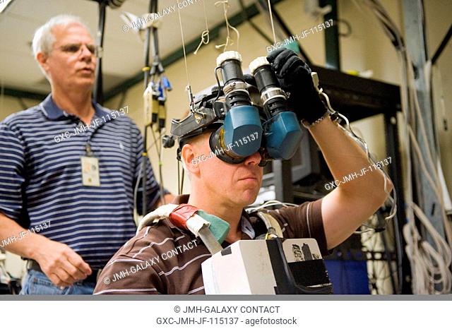 NASA astronaut Tim Kopra, STS-133 mission specialist, uses virtual reality hardware in the Space Vehicle Mock-up Facility at NASA's Johnson Space Center to...
