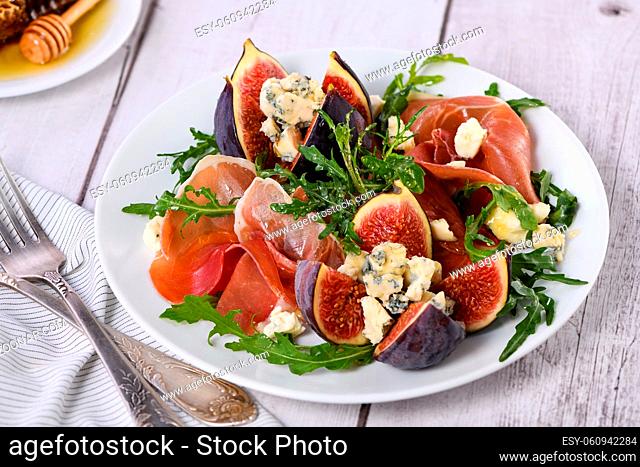 Appetizer arugula with Parma ham and fresh figs stuffed blue cheese, honey