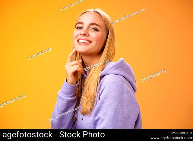 Attractive sassy self-assured caucasian blond female in purple hoodie turning camera touching chin cheeky smile camera check out interesting thing gazing...
