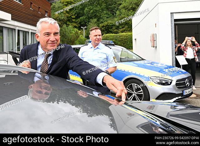 26 July 2023, Baden-Württemberg, Pforzheim: Thomas Strobl (CDU), Interior Minister of Baden-Württemberg, points to a dashcam system behind a window on a police...