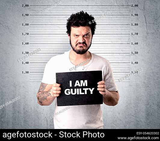 Caugth offender in front of a wall with table in his hand