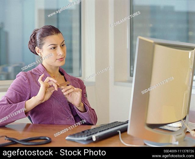 Businesswoman filing her nails at her desk