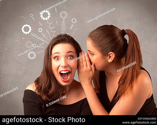 Two girlfriends in elegant black dress sharing secrets with each other concept with drawn rack cog wheels and spiral lines on the wall background