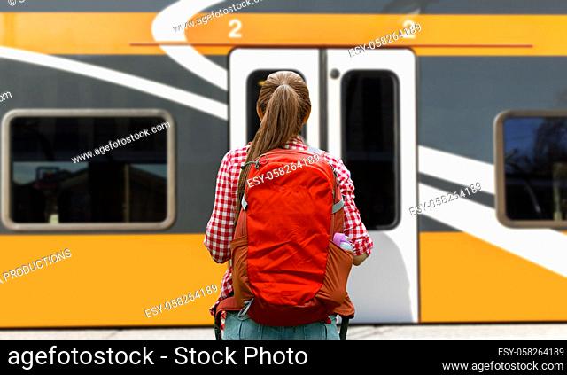 young woman with backpack traveling over train