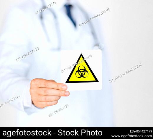 male doctor holding boihazard caution sign
