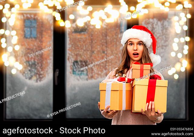 teenage girl in santa hat with christmas gift