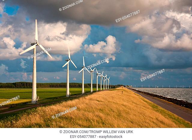 Dutch Windturbines and a cloudscape in the last sunlight of a summer evening