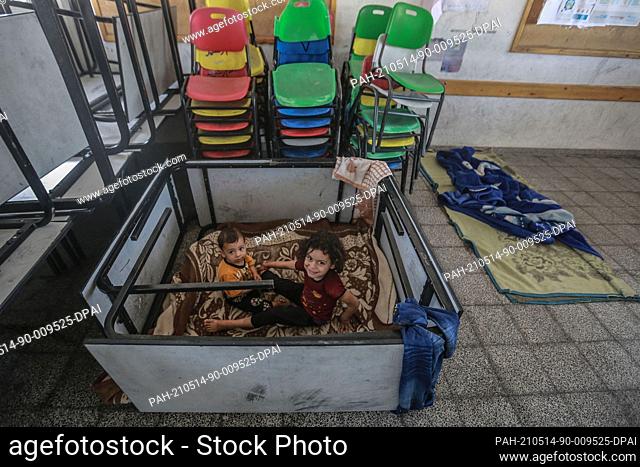 14 May 2021, Palestinian Territories, Gaza City: Children sit inside a UN school in Gaza City where Palestinian families take shelter after fleeing from their...