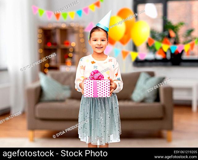 smiling girl in party hat with birthday gift