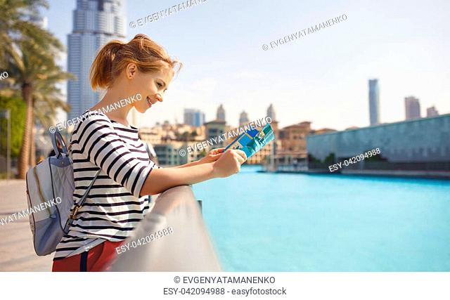 girl tourist travels with a map through streets of city