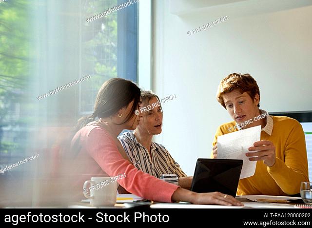 Businessman and businesswoman working in board room