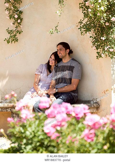 Italy, Florence, Young couple sitting by wall