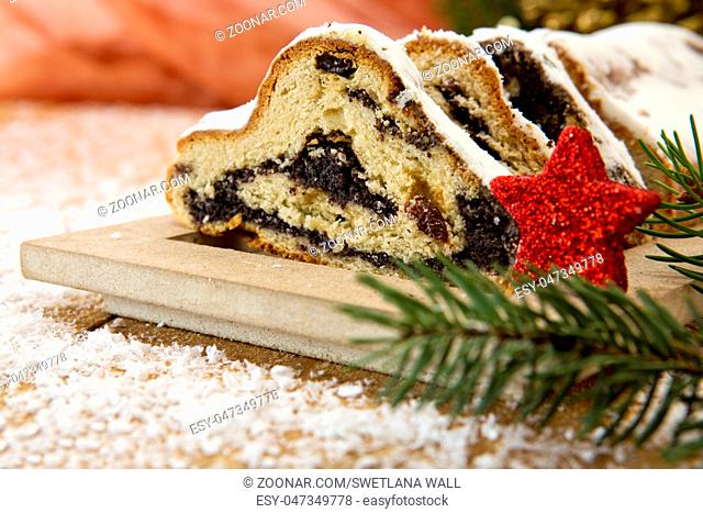 Christmas Cake and Christmas Decorations. Stollen with Marzipan, Berries and Nuts. Photo in Vintage Tone Style