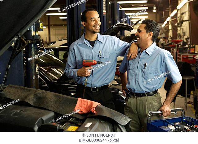 Multi-ethnic male auto mechanics in shop