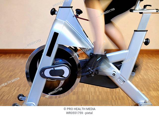 Young woman at an ergometer in a fitness center